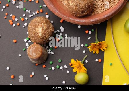 Til Gul ODER Sweet Sesam Laddu mit Drachenmodell, haldi Kumkum und Zuckerkristallen für das Makar Sankranti Festival auf schwarzem Hintergrund. Stockfoto