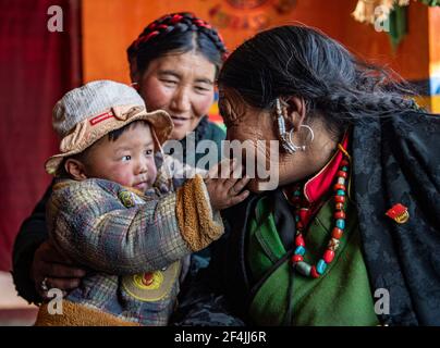 (210322) -- LHASA, 22. März 2021 (Xinhua) -- Tenzin Tsomo interagiert am 25. Februar 2021 mit ihrer Enkelin in der Autonomen Region Tibet im Südwesten Chinas. Tenzin Tsomo, geboren 1942, ist ein Dorfbewohner im Dorf Zhuobabu im Landkreis Saga in Xigaze, Autonome Region Tibet. Als Tenzin Tsomo ein Kind war, musste ihre Familie Schafe für Leibeigene weiden, während sie um ihren Lebensunterhalt bettelte. Zur Verzweiflung getrieben, stahlen sie die Schafe des Leibeigenbesitzers und liefen davon. Es war nicht lange, bis der Leibeigene sie zurückholte. Tenzin Tsomos Vater wurde in Behinderte geschlagen. Ihr Zelt wurde weggenommen, so dass die Familie mich leben musste Stockfoto