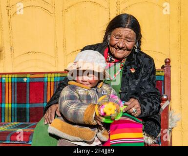 (210322) -- LHASA, 22. März 2021 (Xinhua) -- Tenzin Tsomo und ihre Enkelin ruhen sich am 25. Februar 2021 im Sonnenschein in der Autonomen Region Tibet im Südwesten Chinas aus. Als Tenzin Tsomo ein Kind war, musste ihre Familie Schafe für Leibeigene weiden, während sie um ihren Lebensunterhalt bettelte. Zur Verzweiflung getrieben, stahlen sie die Schafe des Leibeigenbesitzers und liefen davon. Es war nicht lange, bis der Leibeigene sie zurückholte. Tenzin Tsomos Vater wurde in Behinderte geschlagen. Ihr Zelt wurde weggenommen, so dass die Familie in einer Höhle leben musste. Tenzin Tsomos Leben hat seit der demokratischen Reform einen gewaltigen Wandel erfahren Stockfoto