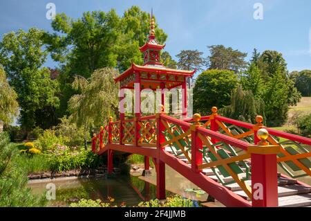 Blumenpark und Gärten mit roter chinesischer Pagodenbrücke im malerischen Dorf Apremont-sur-Allier, das als eines der schönsten Dörfer aufgeführt ist Stockfoto