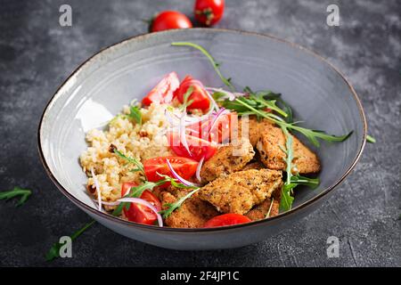 Gekochter Bulgur, gebratene Chicken Nuggets und frischer Tomaten-Salat. Mittelöstliche Küche. Stockfoto