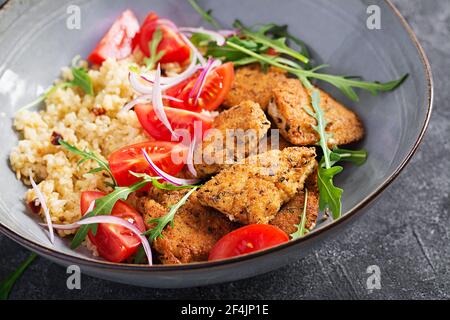 Gekochter Bulgur, gebratene Chicken Nuggets und frischer Tomaten-Salat. Mittelöstliche Küche. Stockfoto