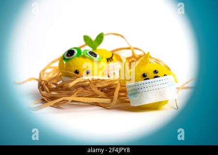 Baby Spielzeug Huhn trägt chirurgische Gesichtsmaske auf weißem Hintergrund mit Kopie Raum. Covid-19 Pandemie und feiern Feiertage mit Coronavirus abstrakt Stockfoto