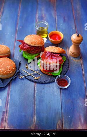 Fleischburger mit geräuchertem Käse und knusprigem Speck Stockfoto