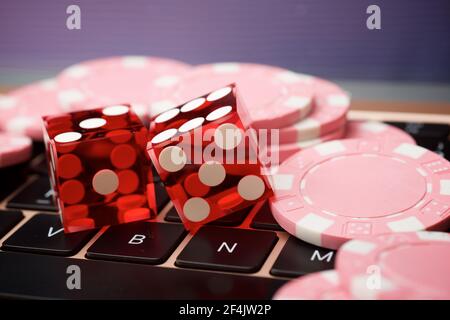 Casino Chips und Würfel Stapeln auf einem Laptop. Stockfoto