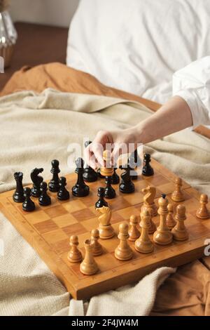 Schachspielerin Frau Lernt Schacheröffnung, Indem Sie Mit Sich Selbst Spielt. Weißer Bauer Einen Schritt Vorwärts. Schachbrett Aus Holz Mit Schachfiguren Auf Hellem Hintergrund. Strategie Board Spiel Gespielt. Nahaufnahme Toned Photo Stockfoto