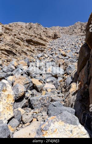 Felssturz und Gleitsteine von einem Wanderweg zum Jabel Jais Gipfel im Hajar Gebirge, Vereinigte Arabische Emirate gesehen. Stockfoto