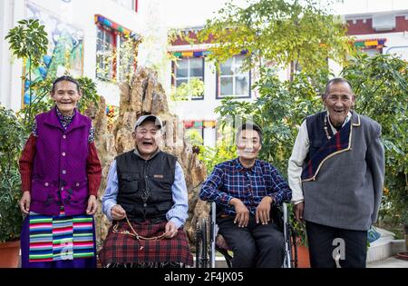 (210322) -- LHASA, 22. März 2021 (Xinhua) -- Cedain (1st R) posiert für ein Gruppenfoto mit seinen Freunden im Pflegezentrum in der Präfektur Ngari, südwestlich der Autonomen Region Tibet, 19. März 2021. Cedain, geboren 1941, ist ein Dorfbewohner des Dorfes Qianjin im Kreis gar, Präfektur Ngari, Autonome Region Tibet. Ohne Ackerland und genügend Nahrung lebte der ehemalige Leibeigene mit seiner Familie in alten Zeiten vom Betteln. Eine solche Notlage endete 1959, nachdem eine demokratische Reform mehr als 1 Millionen Menschen oder 90 Prozent der Bevölkerung der damaligen Region von der feudalen Leibeigenschaft befreite Stockfoto