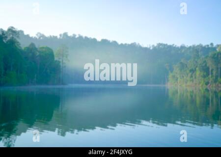 Unverschämtes Bokeh Hintergrund von Wald und See mit Morgennebel. Konzept der Naturkulisse. Stockfoto