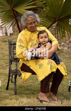 Glückliche Momente mit Oma, indische oder asiatische ältere Dame verbringen Zeit mit ihrer Enkelin im Garten. Stockfoto