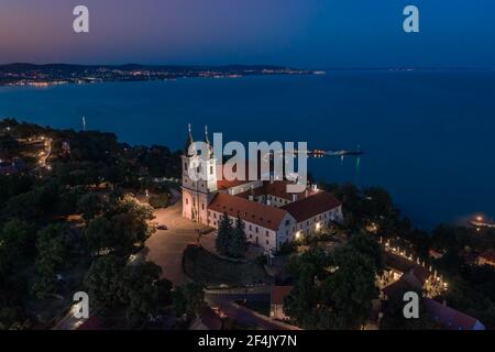 Tihany, Ungarn - Luftpanorama des beleuchteten Benediktinerklosters von Tihany (Tihany Abtei, Tihanyi Apatsag) mit dem Plattensee im Hintergrund Stockfoto