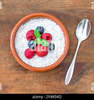 Chia-Samenpudding mit frischen Beeren auf Holztisch. Chia Samen Joghurt. Stockfoto