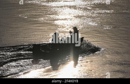 22. März 2021, Brandenburg, Frankfurt (oder): Zwei Angler segeln in einem Motorboot im Licht der Morgensonne auf der deutsch-polnischen Grenzfluß oder stromaufwärts. Foto: Patrick Pleul/dpa-Zentralbild/ZB Stockfoto