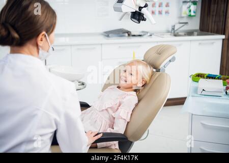 Eine junge Zahnärztin, die eine gründliche Untersuchung der Die Zähne ihrer Patientin Stockfoto