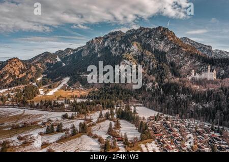 Luftdrohnenaufnahme des malerischen Schlosses Neuschwanstein auf einem verschneiten Hügel Im Winter Sonnenlicht in Deutschland Stockfoto