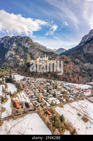 Luftdrohnenaufnahme des malerischen Schlosses Neuschwanstein auf einem verschneiten Hügel Im Winter Sonnenlicht in Deutschland Stockfoto