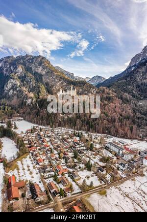 Luftdrohnenaufnahme des malerischen Schlosses Neuschwanstein auf einem verschneiten Hügel Im Winter Sonnenlicht in Deutschland Stockfoto