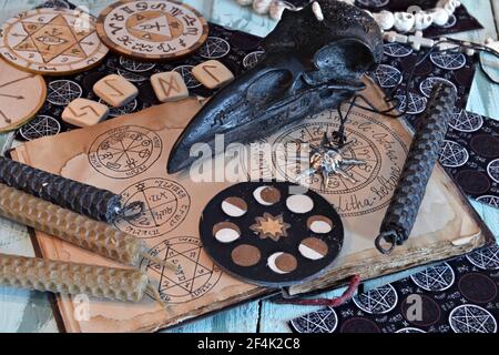 Stillleben mit Hexentagebuch mit Wiccan-Symbolen, Kerzen, Holzkreis mit Mondphasen. Esoterischer, gotischer und okkulter Hintergrund, Halloween Mystic Co Stockfoto