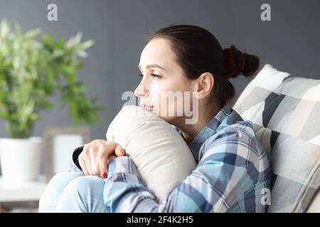 Porträt der jungen traurigen Frau auf der Couch sitzen Stockfoto