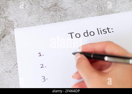 Handschriftliche Geschäftsplan, Strategie oder Ziele. To-do-Liste auf leerer Papierseite auf hellgrauem Steinhintergrund Nahaufnahme Stockfoto