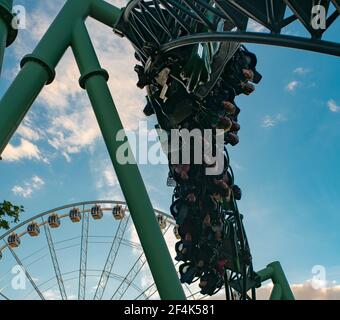 Menschen, die während der Roller Coaster Ride Helix schreiend und die Hände hochhalten Stockfoto