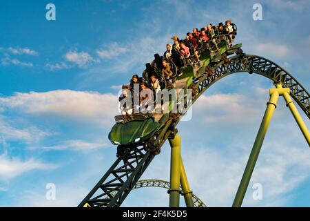 Die Leute schrien und halten die Hände während der Achterbahnfahrt Helix hoch Stockfoto