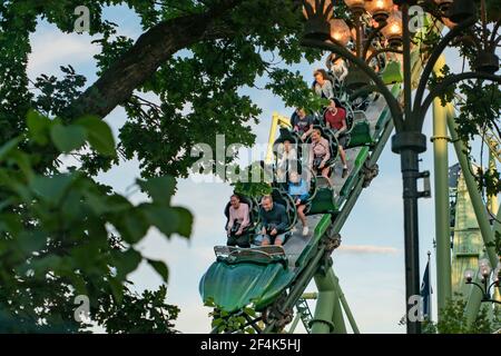 Menschen, die während der Roller Coaster Ride Helix schreiend und die Hände hochhalten Stockfoto