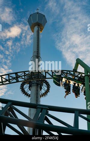 Menschen, die während der Roller Coaster Ride Helix schreiend und die Hände hochhalten Stockfoto