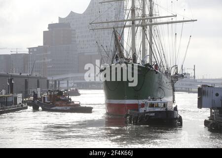 Hamburg, Deutschland. März 2021, 22nd. Mit Schleppern geschleppt, fährt das Museumsschiff 'Rickmer Rickmers' auf der Elbe im Hamburger Hafen zu einem Liegeplatz auf der Werft Blohm & Voss. Im Hintergrund ist die Elbphilharmonie zu sehen. Nach Angaben der Rickmer Rickmers Foundation hatten niedrige Wasserverhältnisse das Schiff immer wieder zu Boden gebracht. Die Elbe ist am Liegeplatz so verstummt, dass das Gelände ausgebagt werden muss. Kredit: Bodo Marks/dpa/Alamy Live Nachrichten Stockfoto