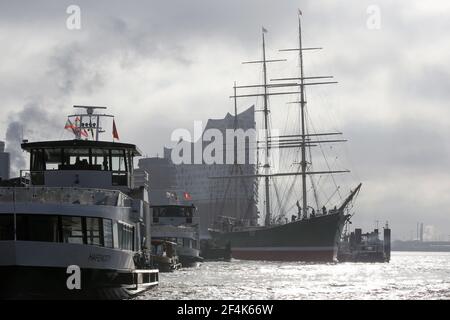 Hamburg, Deutschland. März 2021, 22nd. Mit Schleppern geschleppt, fährt das Museumsschiff 'Rickmer Rickmers' auf der Elbe im Hamburger Hafen zu einem Liegeplatz auf der Werft Blohm & Voss. Im Hintergrund ist die Elbphilharmonie zu sehen. Nach Angaben der Rickmer Rickmers Foundation hatten niedrige Wasserverhältnisse das Schiff immer wieder zu Boden gebracht. Die Elbe ist am Liegeplatz so verstummt, dass das Gelände ausgebagt werden muss. Kredit: Bodo Marks/dpa/Alamy Live Nachrichten Stockfoto