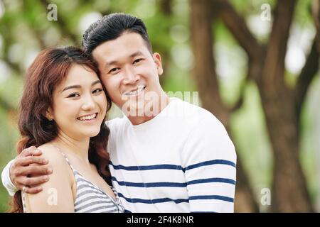 Portrait von glücklich umarmt junge asiatische Freund und Freundin lächelnd Und Blick auf die Kamera Stockfoto