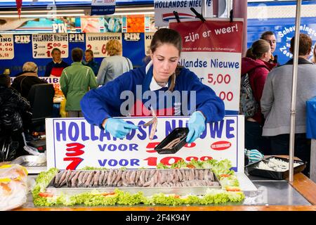 Tilburg, Niederlande. Junge, Jugendliche Frau, die in einem Fischstand auf dem lokalen, Koningsplein, wöchentlichen Samstagsmarkt arbeitet. Für diese nicht identifizierte junge Frau ist es eine Möglichkeit, zu lernen, wie man arbeitet, wie man mit Finanzen umgeht, und das Taschengeld von ihren Eltern zu ergänzen, wodurch sie langsam in ihrer eigenen Unabhängigkeit wächst. Stockfoto