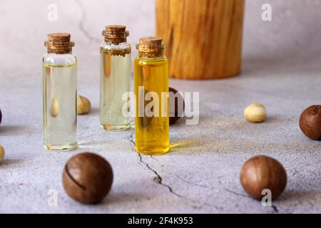 Nahaufnahme von natürlichem Macadamiaöl und Macadamianüssen auf Steinplatte. Gesundes Produkt. Stockfoto