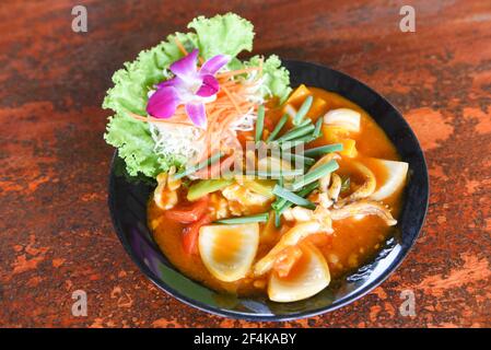 Gebratener Tintenfisch mit gesalzenem Eigelb auf weißem Teller auf Tischhintergrund, Curry-Tintenfisch umrühren Stockfoto