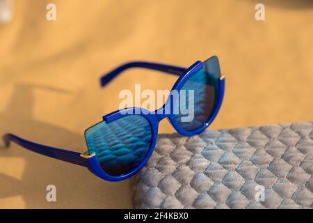 Katzenaugen Sonnenbrille spezielles Modell für Frauen mit blauen Linsen schießen draußen in einem sonnigen Tag Nahaufnahme. Selektiver Fokus Stockfoto