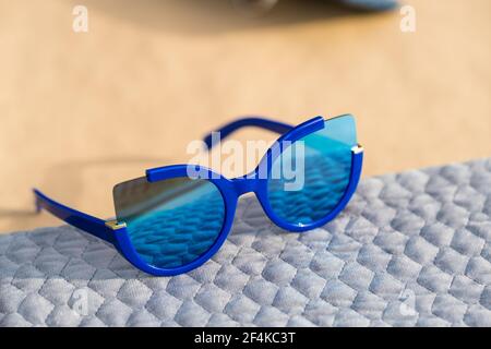 Katzenaugen Sonnenbrille spezielles Modell für Frauen mit blauen Linsen schießen draußen in einem sonnigen Tag Nahaufnahme. Selektiver Fokus Stockfoto