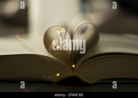 Herzförmige gefaltete Buchkunst mit Lichterketten - valentinstag Stockfoto