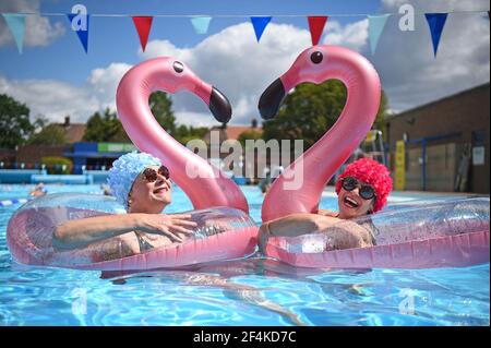 Datei Foto vom 11/07/20 von Schwimmern Nicola Foster (links), 55, und Jessica Walker, 56, genießen Sie das Wasser im Charlton Lido & Lifestyle Club in Hornfair Park, London als Outdoor-Swimmingpools für die Öffentlichkeit wieder geöffnet. Am Dienstag jährt sich zum ersten Mal die Ankündigung der ersten UK-weiten Sperre am 23. März 2020. Ausgabedatum: Montag, 22. März 2021. Stockfoto