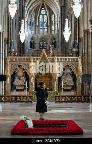 Datei-Foto vom 07/11/20 von Königin Elizabeth II., die einen Blumenstrauß inspiziert, der von ihrem Equerry, Oberstleutnant Nana Kofi Tmumasi-Ankrah, während einer Zeremonie in Westminster Abbey, London, in ihrem Namen am Grab des unbekannten Kriegers platziert wurde. Am Dienstag jährt sich zum ersten Mal die Ankündigung der ersten UK-weiten Sperre am 23. März 2020. Ausgabedatum: Montag, 22. März 2021. Stockfoto