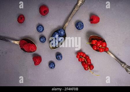 Verschiedene Arten von Beeren in den Löffeln. Stockfoto