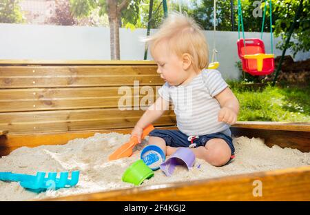 Niedliche kleine Kleinkind Junge spielen in der Sandbox Stockfoto