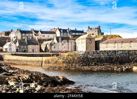 PORTSOY ALTER HAFEN MORAY FIRTH ABERDEENSHIRE SCHOTTLAND GELBE STEINBLÖCKE IN DER WAND ALTE LAGERHÄUSER AM KAI Stockfoto