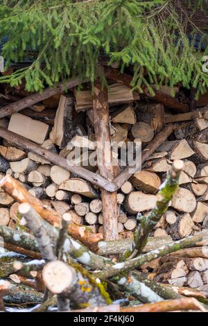 Stapel oder Stapel aus Blöcken, Stücken oder Holzstämmen im Winter oder Frühjahr. Stapelholz zum Trocknen und Lagern, vertikal Stockfoto