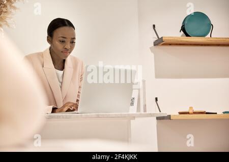 Afroamerikanische Unternehmerin mit einem Laptop in ihrem Geschäft Stockfoto
