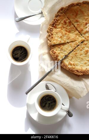 Zwei Tassen Espresso mit knusprigen Käsekuchen-Scheiben. Stockfoto