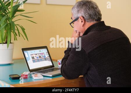 Tilburg, Niederlande. Mann, der sich die Online-Animationen von Kijksluiter ansieht, kurz nachdem er Kartons mit neuen Medikamenten gekauft und gesammelt hat. Stockfoto