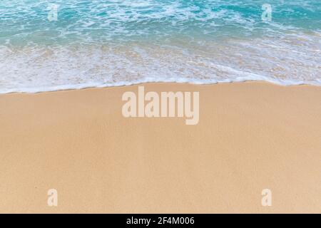 Blaue Meereswelle mit weißem Schaum am Sandstrand in Tropische Insel Stockfoto