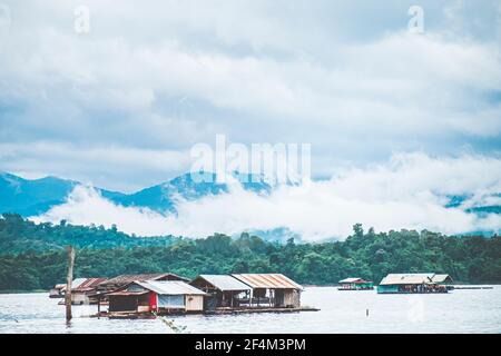 Panorama landschaftlich von Rafting-Haus mit Foggy Mountain im Herbst Am See Stockfoto