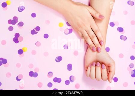 Schöne weibliche Hände auf einem rosa Hintergrund. Stockfoto