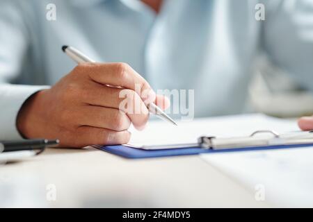 Nahaufnahme Bild des Unternehmers Lesen und Unterzeichnung Vertrag, selektiver Fokus Stockfoto